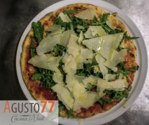 Pizza topped with fresh arugula and parmesan